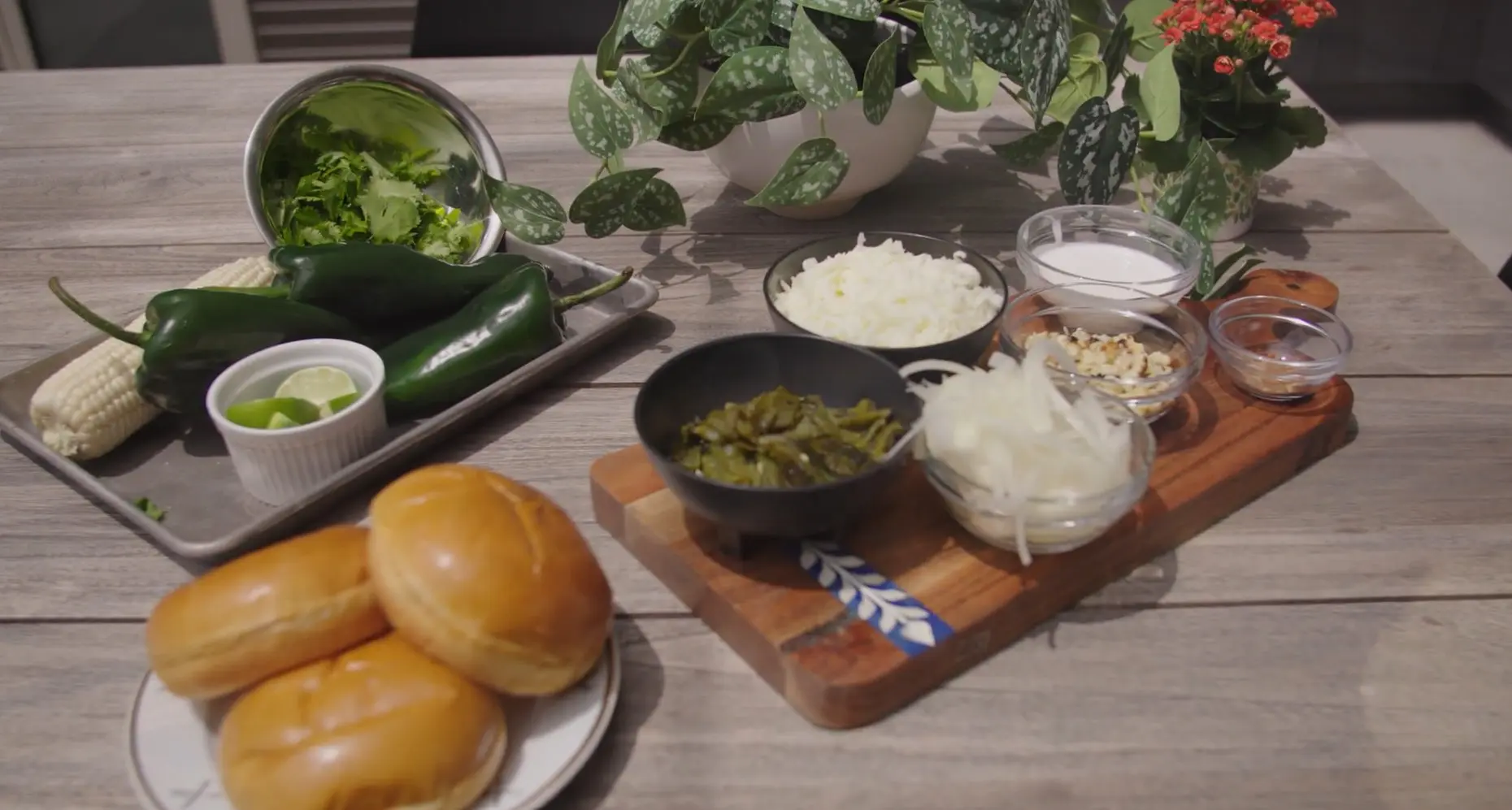 A table with bowls of food and plates on it.